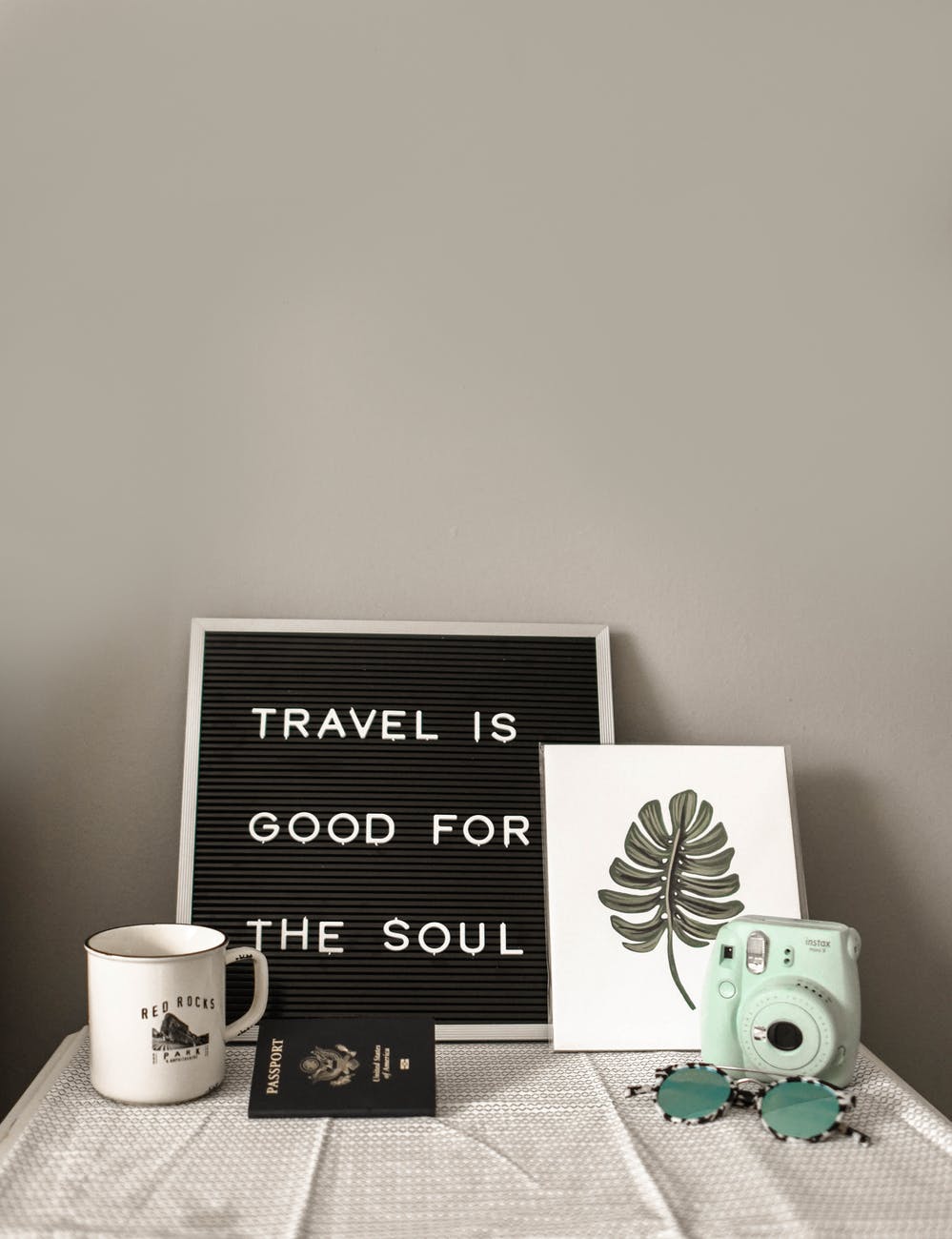 camera near white mug and a travel quote